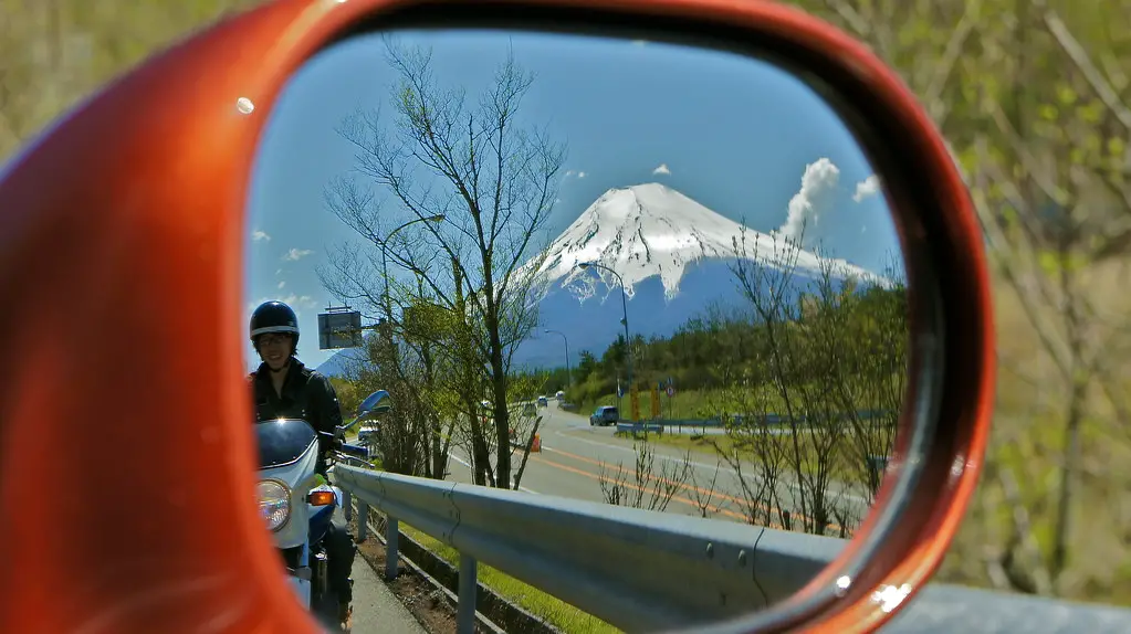 Beautiful view of Mt Fuji from a car's rear view mirror