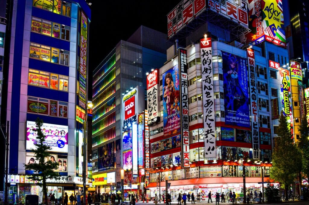 A nighttime view of Akihabara in Tokyo with anime billboards and neon lights