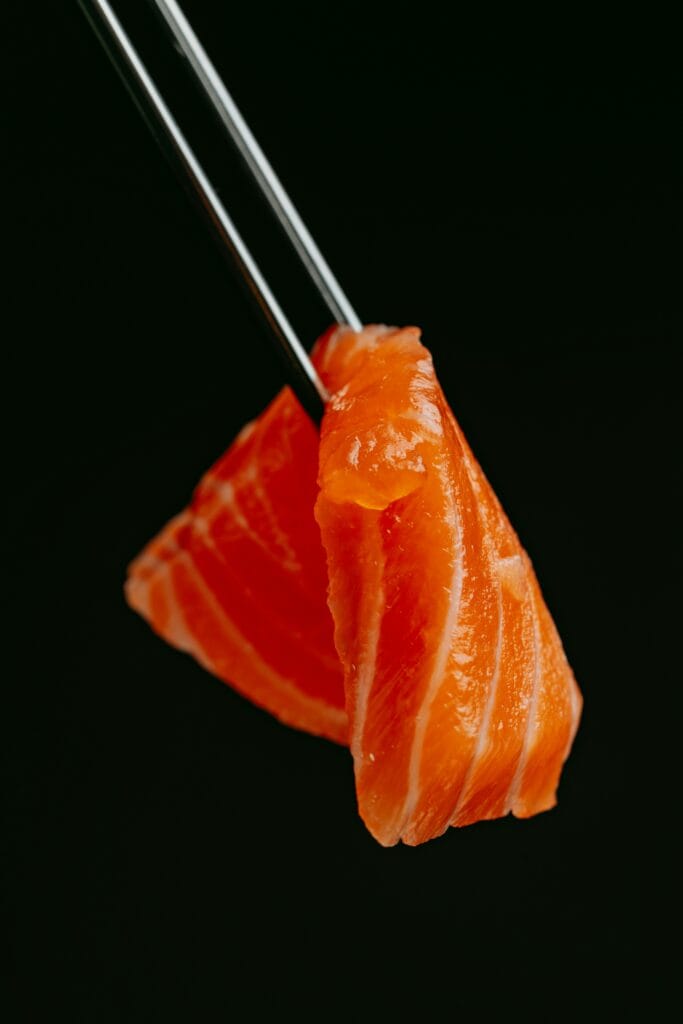 Salmon Sashimi held with chopsticks